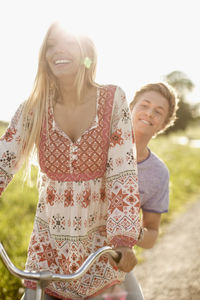 Happy young couple enjoying bicycle ride at countryside