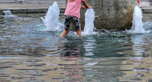 Low section of woman standing on water