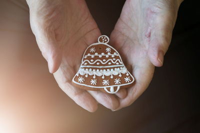 Close-up cropped of hands holding gingerbread cookie