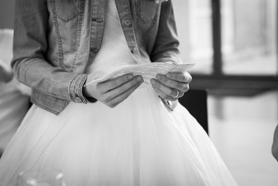 Midsection of woman holding paper