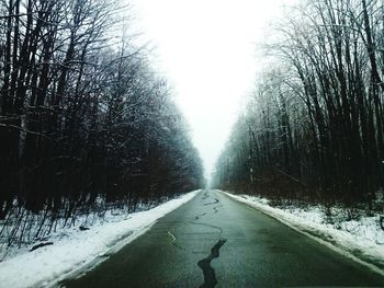 Road passing through snow covered landscape