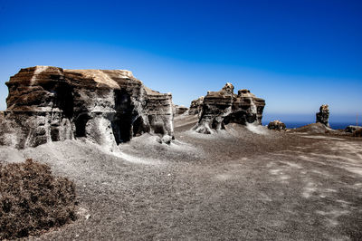 Panoramic view of rocks against clear blue sky