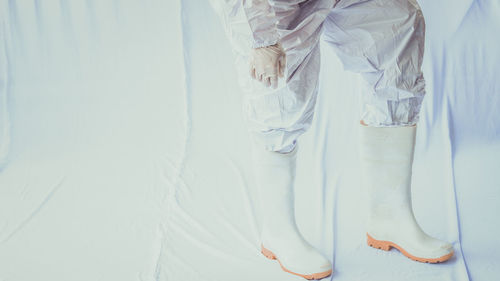 Low section of woman standing on white floor