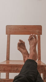 Low section of man relaxing on hardwood floor