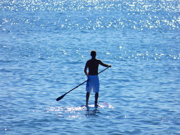 High angle view of man paddleboarding on sea