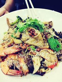 Close-up of hand holding food in plate