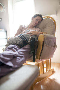 Young woman sitting on sofa at home