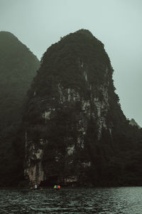 Rock formations by sea against sky