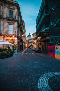 Surface level of empty road against buildings in city