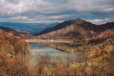 Scenic view of lake by mountains against sky