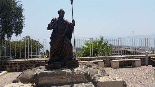 Statue in front of built structure against sky