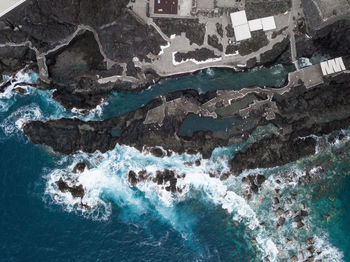 Aerial view of sea waves splashing on coastline