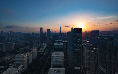 Aerial view of buildings in city against sky during sunset