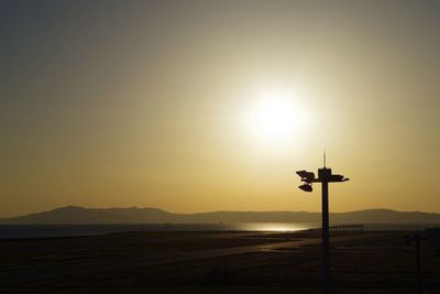 Scenic view of silhouette mountains against sky during sunset at airport