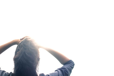 Woman holding hands against clear sky