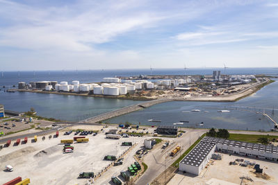 High angle view of city by sea against sky