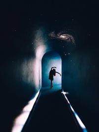 Low angle view of silhouette man standing in tunnel