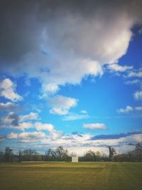 Scenic view of field against cloudy sky