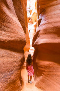 Rear view of woman standing on rock formations