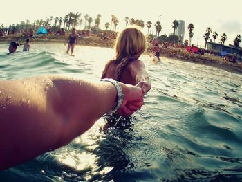 People enjoying on beach against sky