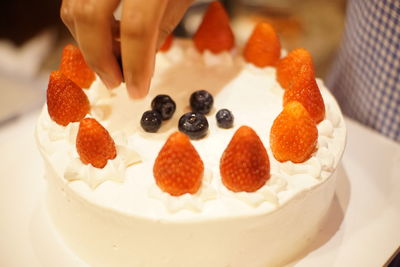 Close-up of hand holding cake