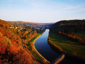 Scenic view of river amidst trees against sky during autumn