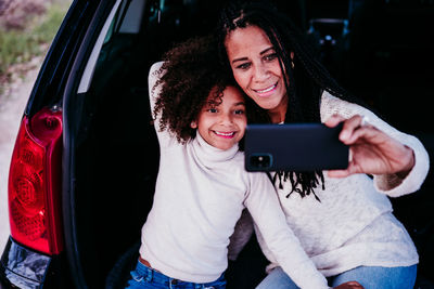 Portrait of a smiling young woman using mobile phone