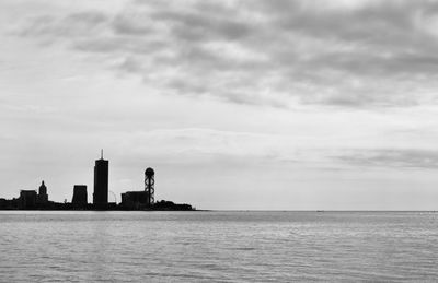 Scenic view of sea by buildings against sky