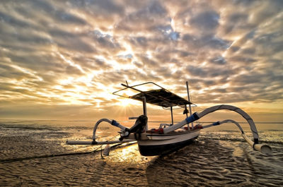 Lone boat in calm sea at sunset