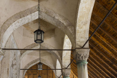 Low angle view of pendant lights hanging from ceiling of building