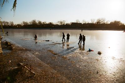 People enjoying in lake against clear sky