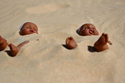 Dolls buried in sand at beach