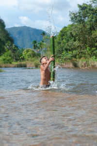 Full length of shirtless man in water