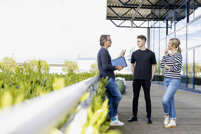 Businessman discussing with colleagues at rooftop