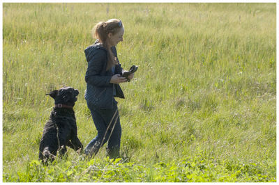 Side view of woman with dog on field