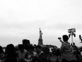 Low angle view of people photographing sculpture