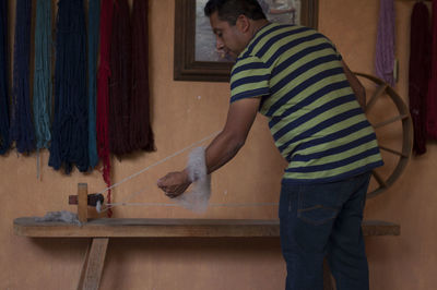 Side view of man standing at home