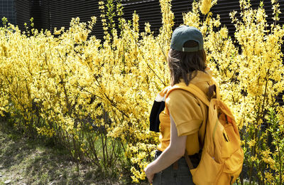 Rear view of man standing amidst plants