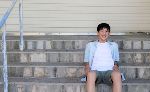 Portrait of smiling girl sitting on staircase