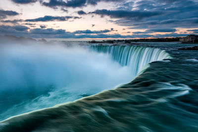 Scenic view of waterfall against sky