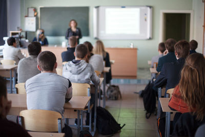 Rear view of students sitting in classroom