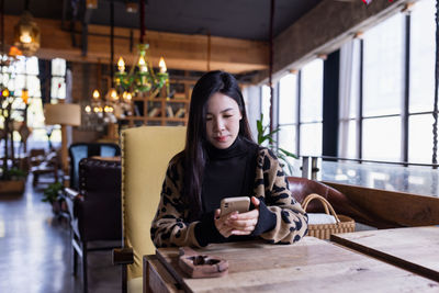 Portrait of young woman sitting on table