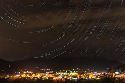 Illuminated city against sky at night