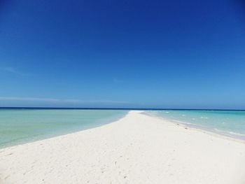 Scenic view of beach against clear blue sky