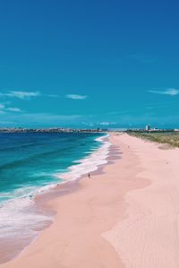 Scenic view of beach against blue sky