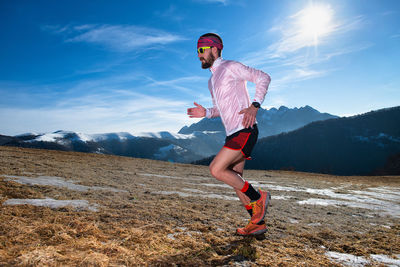 Mountain runner in action uphill on slippery ground