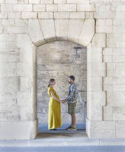 Couple standing against brick wall