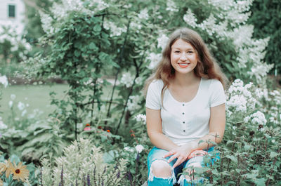 Portrait of smiling young woman sitting outdoors