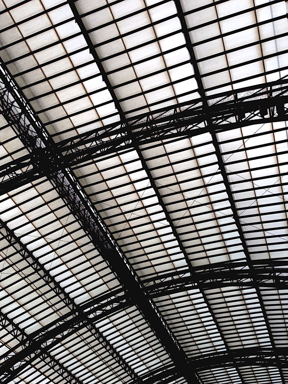 indoors, ceiling, pattern, full frame, architecture, built structure, backgrounds, interior, glass - material, low angle view, architectural feature, skylight, design, modern, geometric shape, no people, railroad station, grid, metal, transparent