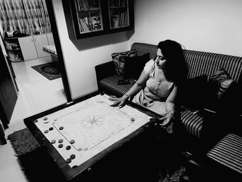 High angle view of woman sitting on table at home